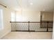 Neutral-toned loft area featuring a decorative iron railing and a window for natural light at 4137 Strendal Dr, Cary, NC 27519