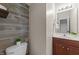 Stylish half-bathroom featuring a wood-accent wall and modern vanity at 415 Moonlight Dr, Fuquay Varina, NC 27526