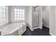Bathroom showcasing a soaking tub with a view and a glass-enclosed shower at 415 Moonlight Dr, Fuquay Varina, NC 27526
