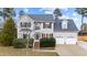 Charming two-story home with a well-manicured lawn, mature bushes, and a two car garage at 415 Moonlight Dr, Fuquay Varina, NC 27526