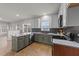 Bright kitchen featuring stainless steel appliances, peninsula, and gray and white cabinets at 415 Moonlight Dr, Fuquay Varina, NC 27526