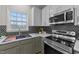 Updated kitchen boasts stainless steel appliances, grey lower cabinets, and a modern backsplash at 415 Moonlight Dr, Fuquay Varina, NC 27526