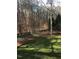 Landscaped backyard featuring a manicured lawn and mature trees, perfect for outdoor enjoyment at 4332 Blossom Hill Ct, Raleigh, NC 27613