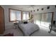 Bright bedroom with large windows, neutral carpet, and a bed with patterned bedding and a ceiling fan at 4332 Blossom Hill Ct, Raleigh, NC 27613