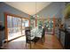 Bright dining room with hardwood floors, a glass table, and sliding glass doors to the deck at 4332 Blossom Hill Ct, Raleigh, NC 27613