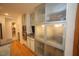 Open kitchen with frosted glass cabinetry and stainless appliances, including built-in microwave and wall oven at 4332 Blossom Hill Ct, Raleigh, NC 27613