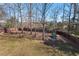 A spacious backyard features mature trees, a swing set, and a private wooden fence at 4711 Marena Pl, Durham, NC 27707