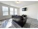 Cozy living room with three windows, dark sofa, and nice flooring at 5 Misty Grove Trl, Franklinton, NC 27525