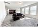 Open-concept living room with plenty of natural light and dark leather sofa at 5 Misty Grove Trl, Franklinton, NC 27525