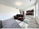 Open-concept living room area with dark sofa and adjacent kitchen space at 5 Misty Grove Trl, Franklinton, NC 27525