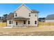 Back exterior view of a beige two-story home with a covered patio and a spacious yard at 51 Blackberry Ln, Benson, NC 27504