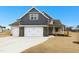 Charming two-story home with a three car garage, stone accents, and a well-manicured lawn on a sunny day at 51 Blackberry Ln, Benson, NC 27504