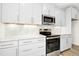 Well-lit kitchen featuring stainless steel appliances, a marble backsplash, and ample white cabinets at 51 Blackberry Ln, Benson, NC 27504