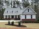Charming two-story home featuring a well-manicured lawn, blue door, dormer windows, and a welcoming porch at 515 Sanctuary Trl, Cameron, NC 28326