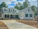 Charming two-story home featuring a well-manicured lawn, blue door, dormer windows, and an attached two car garage at 515 Sanctuary Trl, Cameron, NC 28326