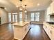 Open-concept kitchen with granite countertops, stainless steel appliances, a large island, and an adjacent living area at 515 Sanctuary Trl, Cameron, NC 28326