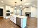 Open-concept kitchen with granite countertops, stainless steel appliances, a large island, and an adjacent living area at 515 Sanctuary Trl, Cameron, NC 28326