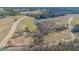 Aerial view of an empty land tract near the pond and road, featuring a small shed at 515 Sanctuary Trl, Cameron, NC 28326