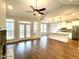 Open-concept living room with hardwood floors, large windows and an eat-in kitchen with an island at 515 Sanctuary Trl, Cameron, NC 28326