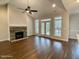 Bright open-concept living room featuring hardwood floors, a stone fireplace, a ceiling fan, and lots of natural light at 515 Sanctuary Trl, Cameron, NC 28326
