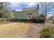 View of the expansive backyard with a light green house and a small wood deck at 6108 King Croydon Ct, Raleigh, NC 27603