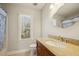Bathroom with a wooden vanity, granite countertop, and window view at 6108 King Croydon Ct, Raleigh, NC 27603