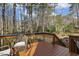 Inviting deck with wood railings and a comfortable wicker chair overlooking a serene wooded area at 6108 King Croydon Ct, Raleigh, NC 27603