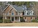 Elegant brick home featuring a covered front porch and well-manicured landscaping at 6108 King Croydon Ct, Raleigh, NC 27603