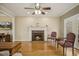 Cozy living room with hardwood floors, ceiling fan, a brick fireplace, and classic furnishings at 6108 King Croydon Ct, Raleigh, NC 27603