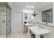 Bright bathroom featuring dual pedestal sinks, a glass-enclosed shower, and a large mirror at 620 Marlowe Rd, Raleigh, NC 27609