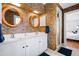 Bathroom with a white double sink vanity, vintage wallpaper, and round mirrors at 620 Marlowe Rd, Raleigh, NC 27609