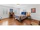 Bright bedroom with hardwood floors, two windows and a wooden writing desk at 620 Marlowe Rd, Raleigh, NC 27609
