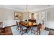 Traditional dining room with hardwood floors, an area rug, wooden table, chandelier, and wainscoting at 620 Marlowe Rd, Raleigh, NC 27609