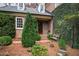 Charming brick home entrance with lush greenery and a cozy bench at 620 Marlowe Rd, Raleigh, NC 27609