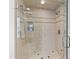Luxurious glass-enclosed shower with tiled walls, a built-in bench, and dual showerheads at 620 Marlowe Rd, Raleigh, NC 27609