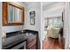 Elegant wet bar with granite countertop, wood cabinetry, and decorative mirror, perfect for entertaining guests at 620 Marlowe Rd, Raleigh, NC 27609