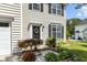 Charming home with a decorative wreath, black shutters, a white front door and a well-manicured garden at 6306 Winding Arch Dr, Durham, NC 27713
