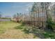 Spacious backyard featuring a black metal fence and a lush grassy area, perfect for outdoor activities at 65 Walking Trl, Youngsville, NC 27596