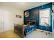 Bedroom with blue accent wall, moon art, and telescope at 65 Walking Trl, Youngsville, NC 27596
