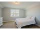 Neutral bedroom features a comfy bed, a window with neighborhood views, and carpeted floors at 65 Walking Trl, Youngsville, NC 27596
