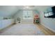 Bright bonus room features wood floors, built-in cabinets and shelves, and a colorful accent rug at 65 Walking Trl, Youngsville, NC 27596