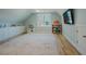 A bonus room or play area, featuring a large rug, storage and entertainment area at 65 Walking Trl, Youngsville, NC 27596