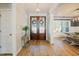 Bright foyer with wood floors, double front doors, and wainscoting in dining room at 65 Walking Trl, Youngsville, NC 27596