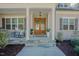Inviting front porch with rocking chairs, hanging light, and beautifully stained wood doors at 65 Walking Trl, Youngsville, NC 27596