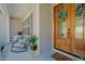 Cozy front porch with rocking chairs, plants, and a lovely wooden front door at 65 Walking Trl, Youngsville, NC 27596