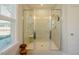 A luxurious shower with a built-in bench, multiple shower heads and tiled walls at 65 Walking Trl, Youngsville, NC 27596