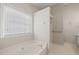 Bright bathroom with a soaking tub under a window at 7 Windsor Glen Dr, Durham, NC 27703