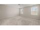 Spacious bedroom with neutral walls, carpet, and two large windows at 7 Windsor Glen Dr, Durham, NC 27703
