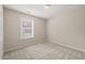 Neutral bedroom featuring plush carpeting, a bright window, and fresh paint at 7 Windsor Glen Dr, Durham, NC 27703