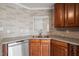 Kitchen sink with stainless steel appliances, wood cabinetry, light countertops, and stone backsplash at 7 Windsor Glen Dr, Durham, NC 27703